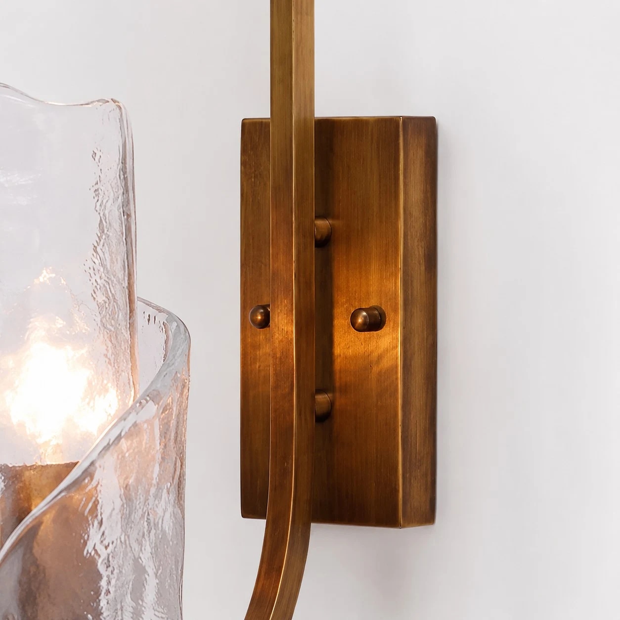 Brass body, rounded support and textured glass shade.