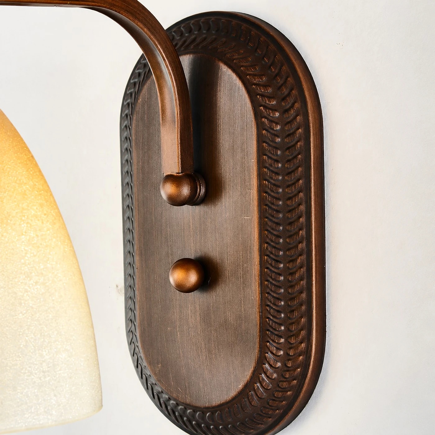 Antique bronze mounting plate and curved arm detail