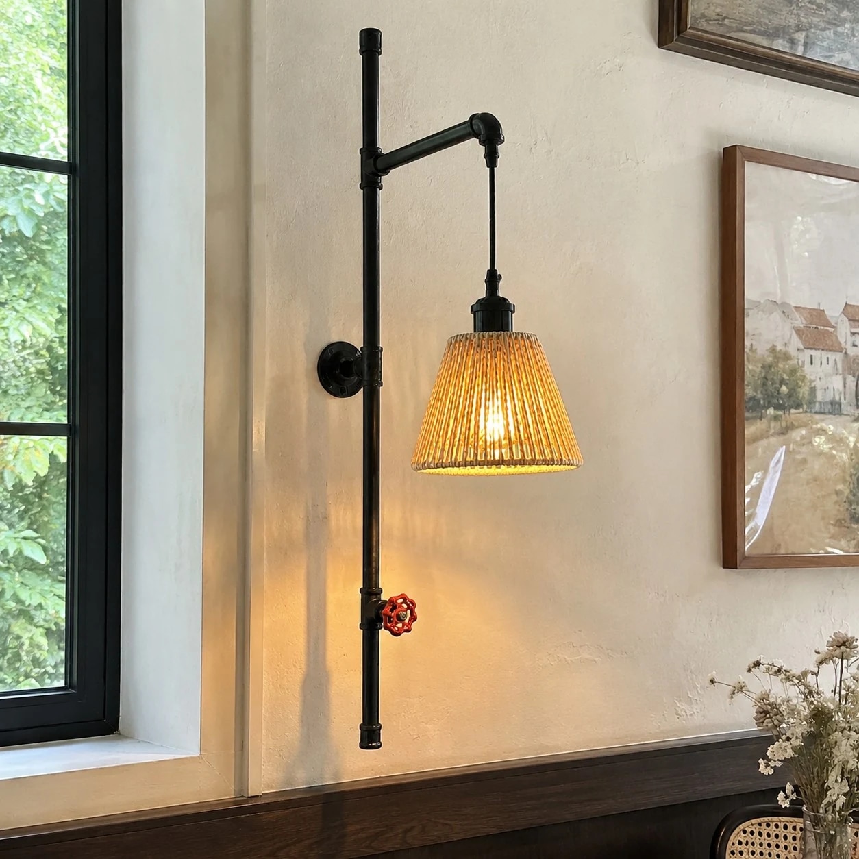 Vintage pipe wall sconce installed beside framed wall decor