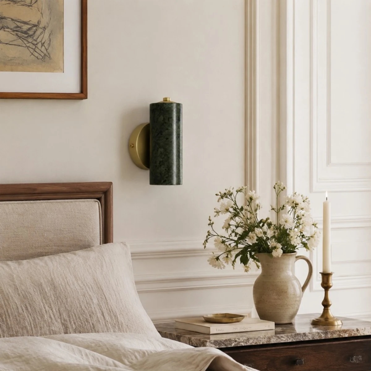 Green jade wall lamp styled above a bedside table with flowers