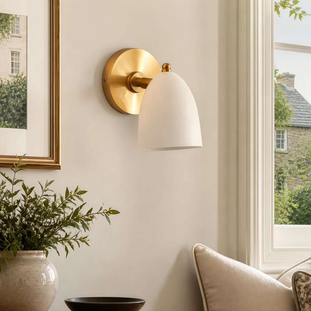 White and gold wall sconce near a window seating area