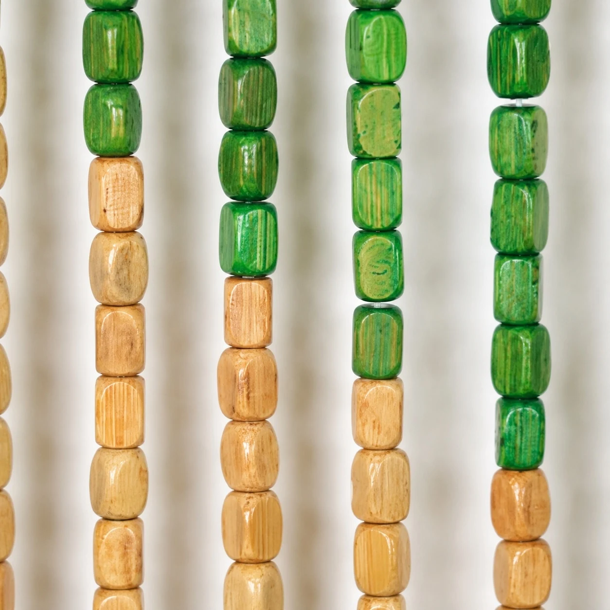 Primo piano di una perlina di legno verde e naturale.