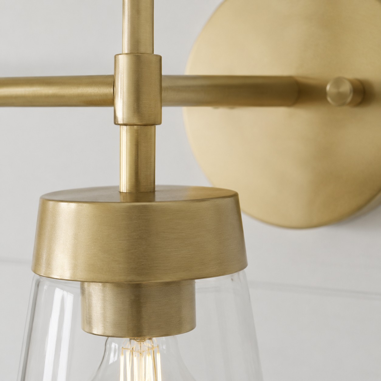 Detailweergave van de geborstelde messing verbinding en de heldere glazen kap.