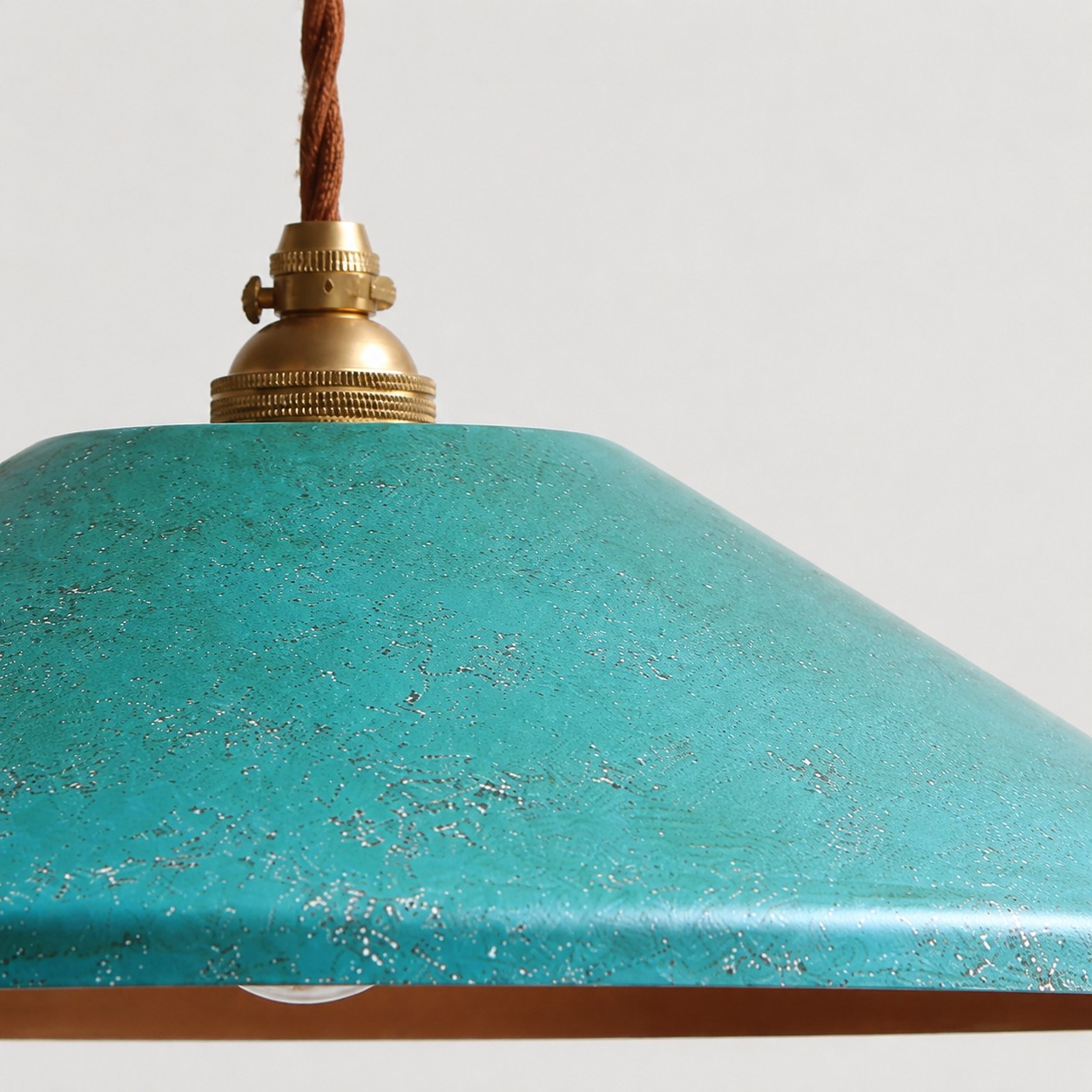 Gros plan sur la texture d'un abat-jour bleu rouillé à la main avec capuchon en laiton