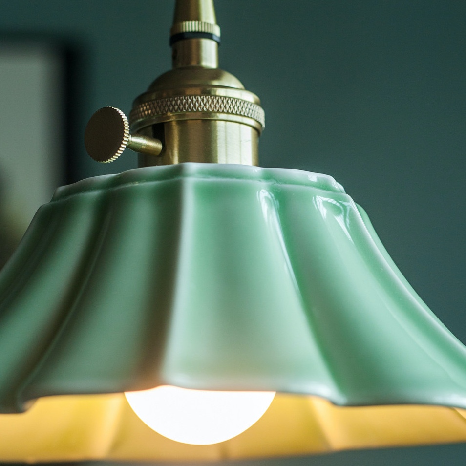 Close view of celadon ceramic shade and brass-tone pendant fitting