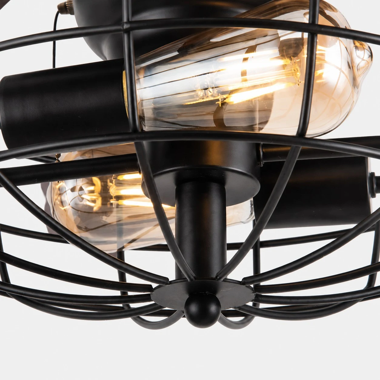 Detailopname van het frame van de lamp met kooi en warm licht.