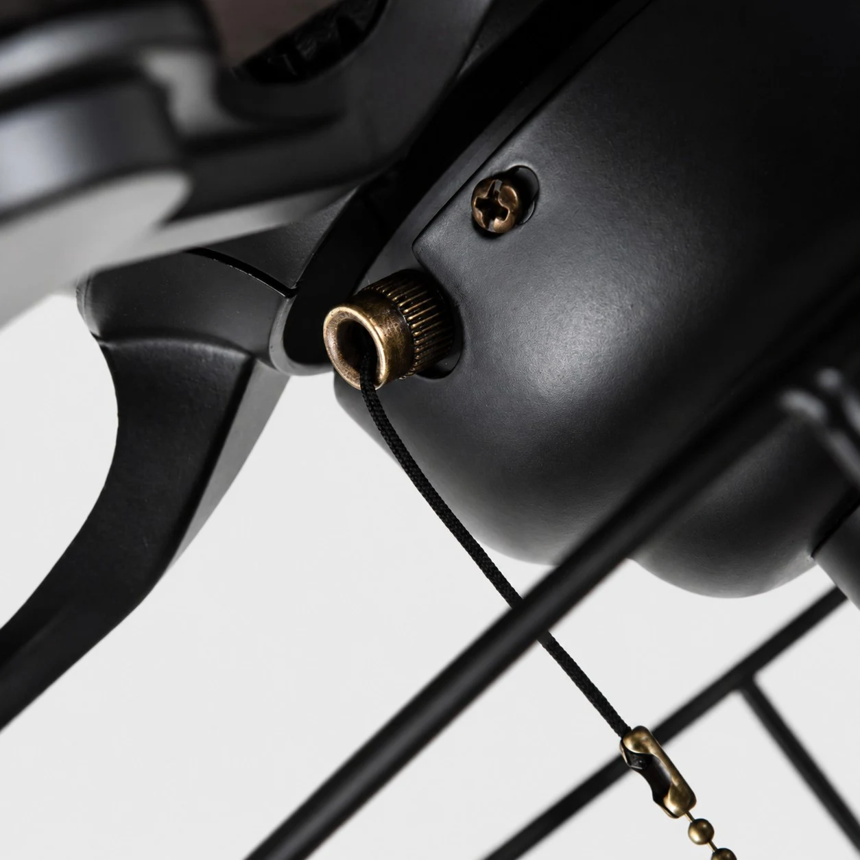 Detailweergave van de zwarte plafondventilatormotor en het trekkoord.