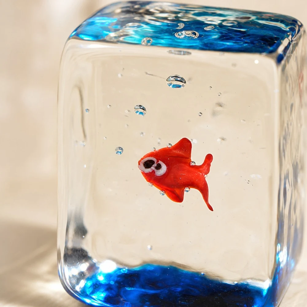 Dettaglio ravvicinato di un ornamento a forma di pesce rosso in blocco di vetro trasparente.