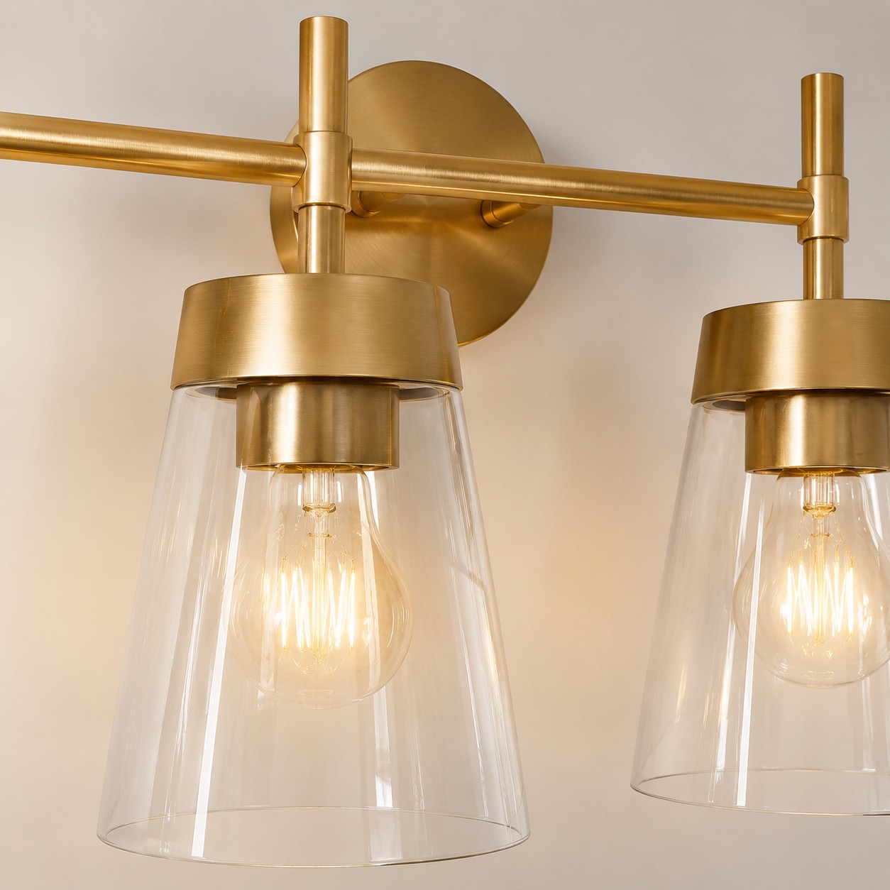 Badkamerlamp met kap van geborsteld messing en helder glas.