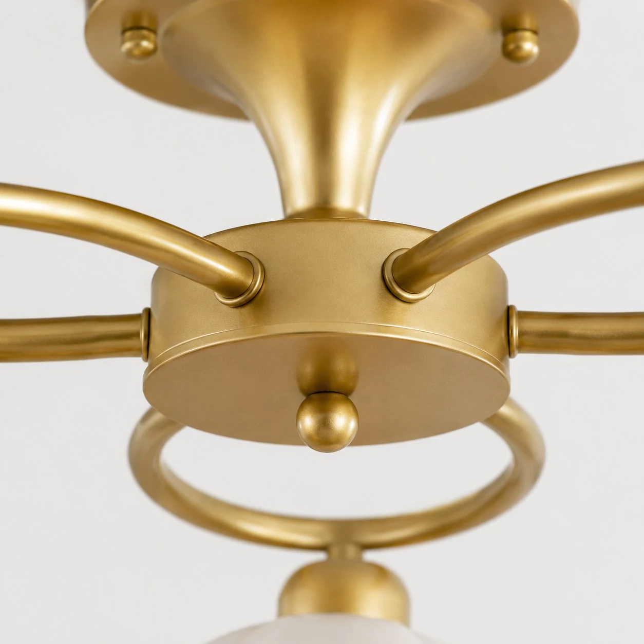 Brass-tone center connection and curved arm detail