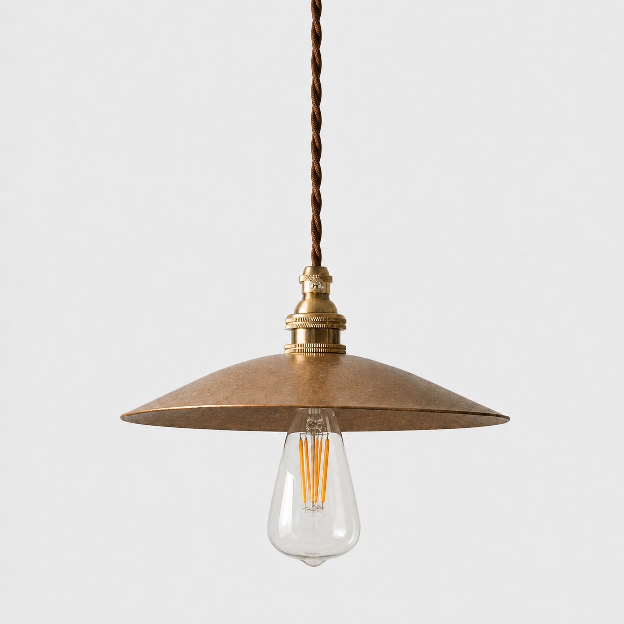 Hammered brass pendant on white background