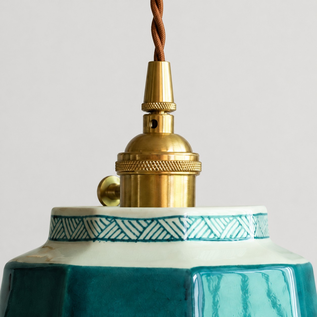 Brass socket and braided cord detail on ceramic pendant light