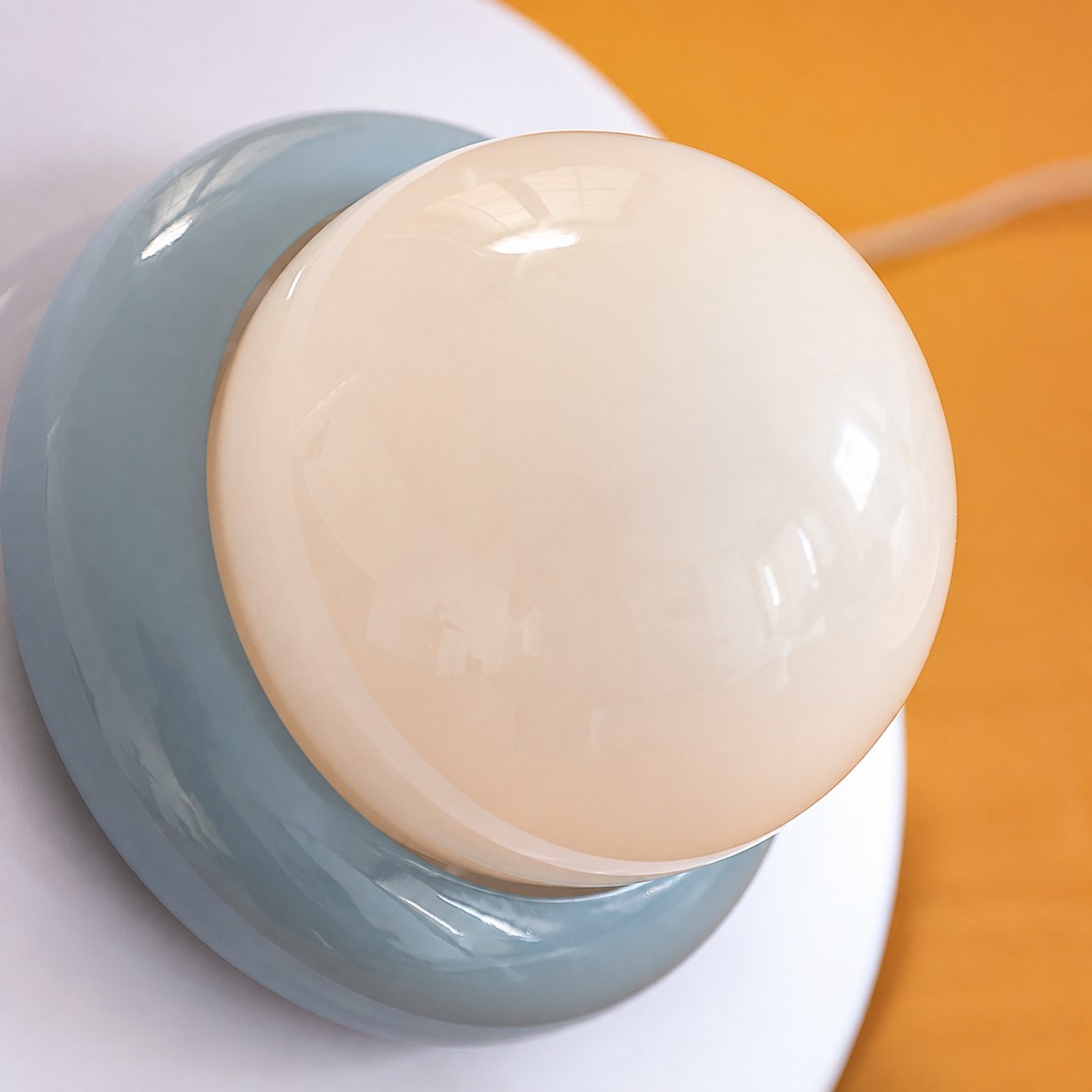 Primer plano del difusor de globo de cristal opalino y la pantalla azul.