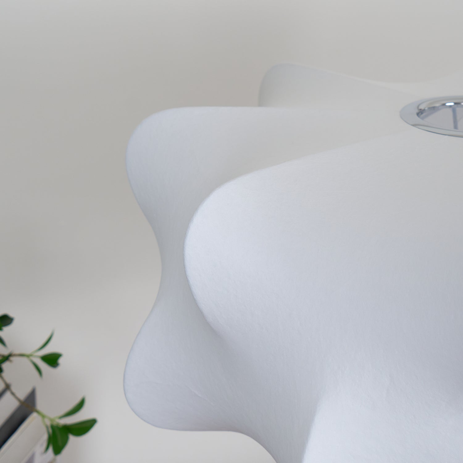 Primo piano del paralume bianco a sospensione che mostra la sua texture fine e i bordi leggermente curvi.