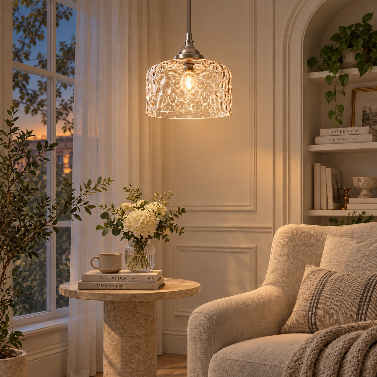 Colgante de cristal cromado con burbujas brillando junto a un sillón al atardecer