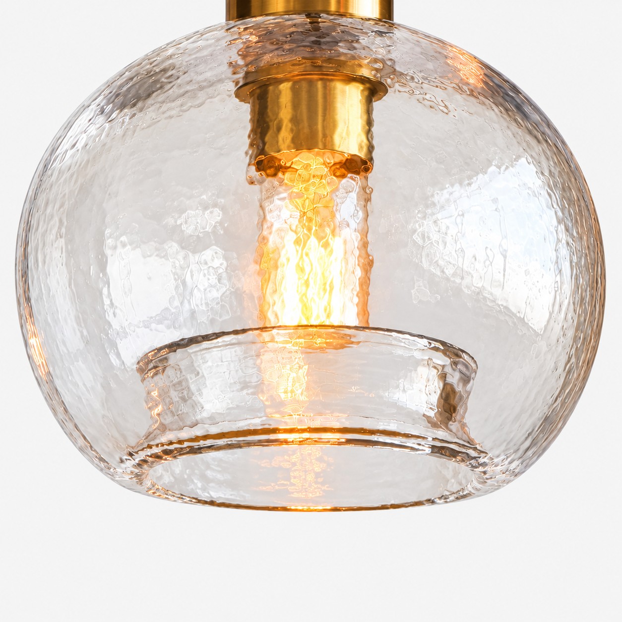 Eine beleuchtete Glühlampe ist durch eine strukturierte Glaskugel mit offenem Sockel sichtbar.