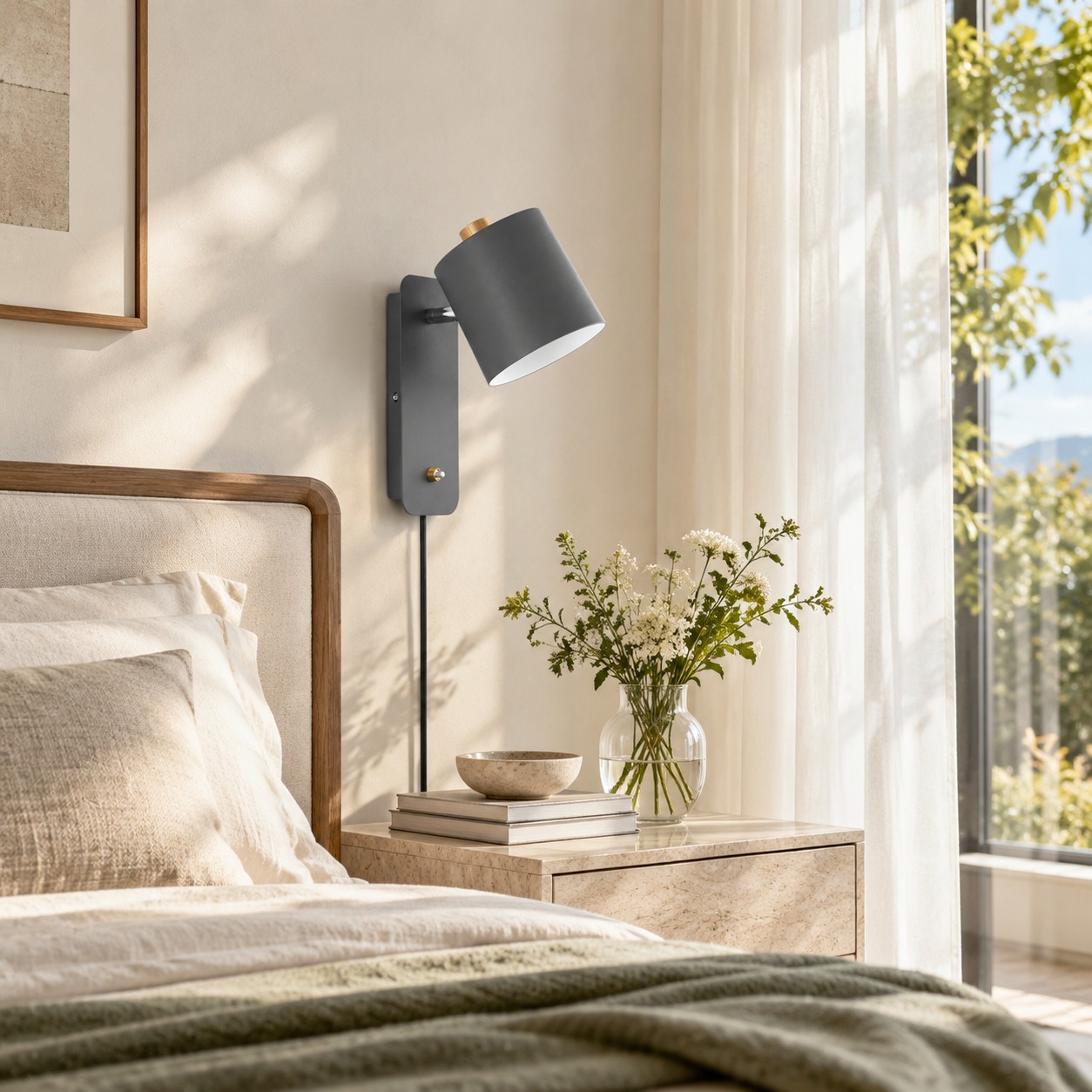 Graue zylinderförmige Wandlampe neben einem Bett im Tageslicht, bevor sie eingeschaltet wird