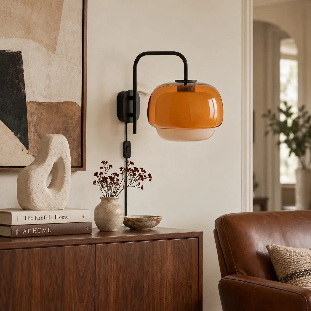 Eine orangefarbene Wandlampe aus Kunstharz über einem Sideboard im Wohnzimmer.