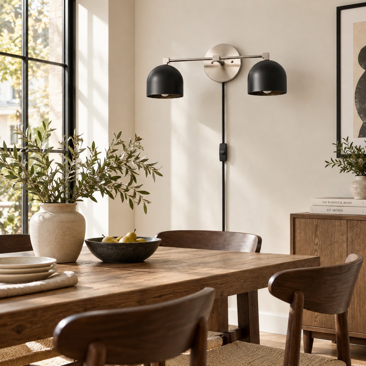 Schwarze, kuppelförmige Wandlampe an der Esszimmerwand neben dem Tisch.